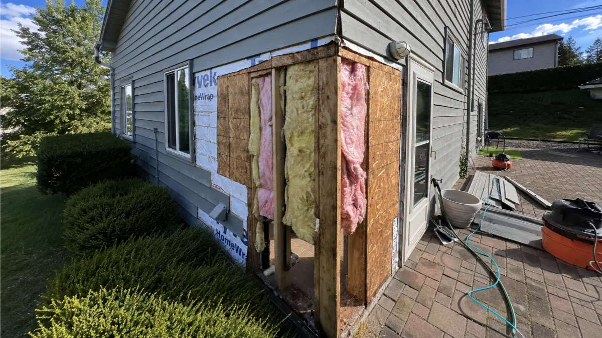 Exterior wall framing and insulation exposed during a wood rot repair