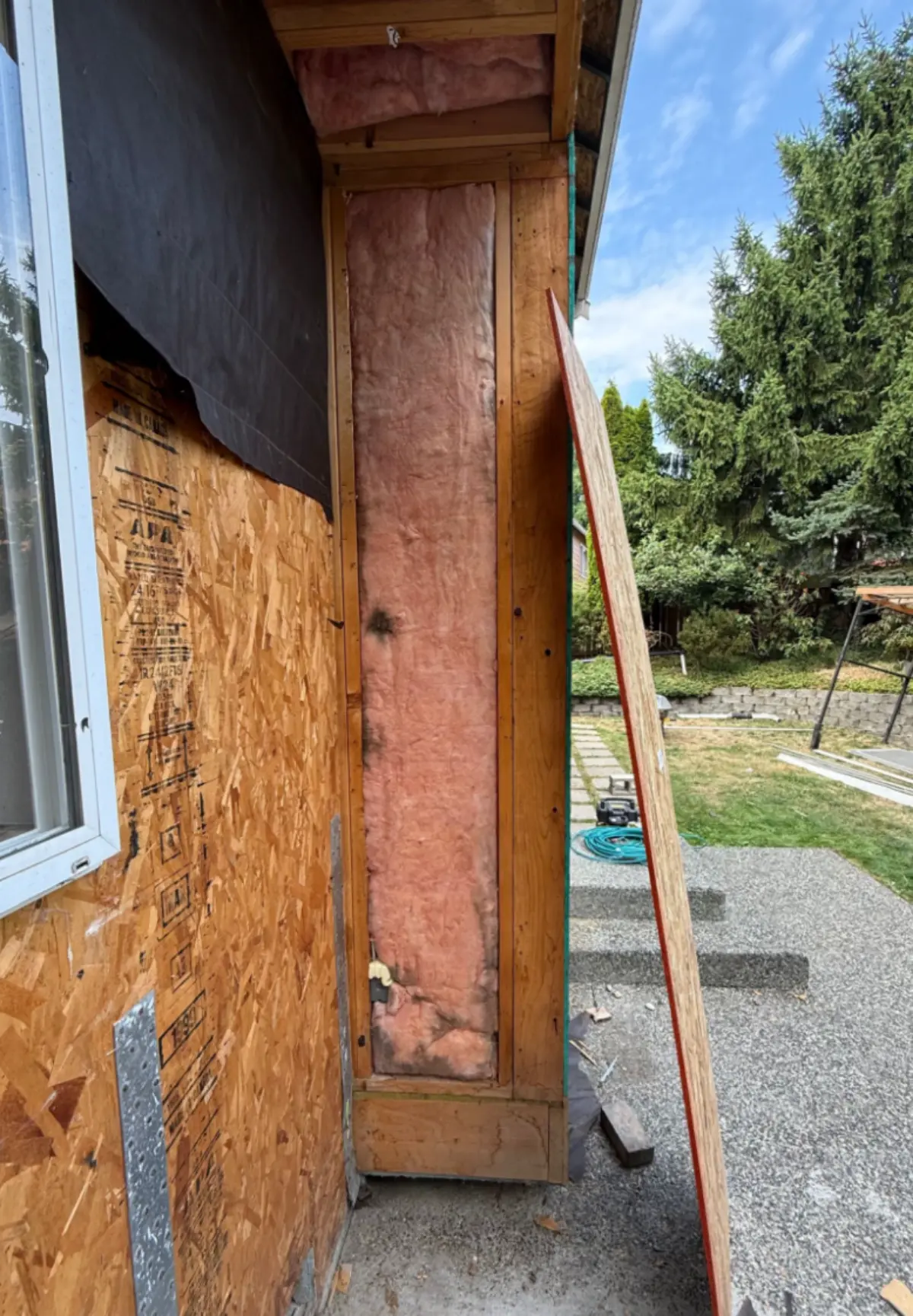Exposed corner post showing water-damaged framing